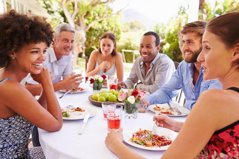 A welcoming group of people sitting around a table having a meal.