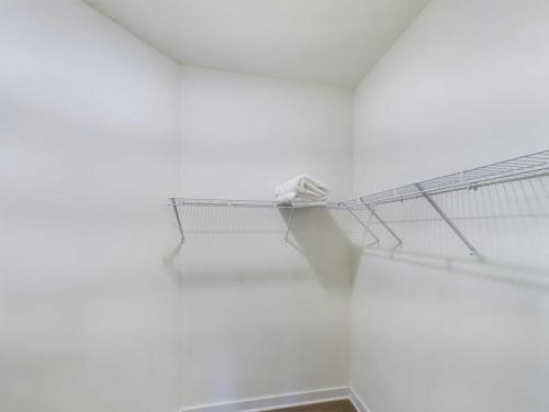 Apartments in Thompson’s Station Empty closet with white walls, featuring wire shelving and a stack of folded towels in one corner. Sanctuary Bluff Apartments in Thompson’s Station