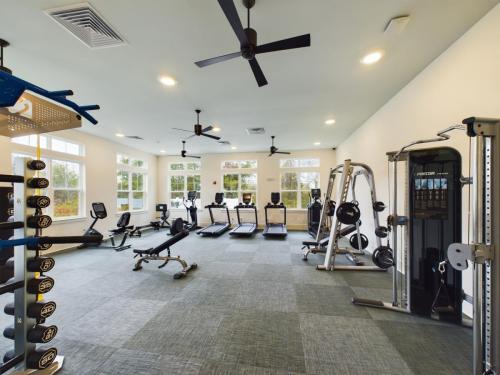 Apartments in Thompson’s Station Fitness center with exercise equipment including treadmills, weight machines, and dumbbells. Large windows provide natural light. Ceiling fans overhead. Sanctuary Bluff Apartments in Thompson’s Station